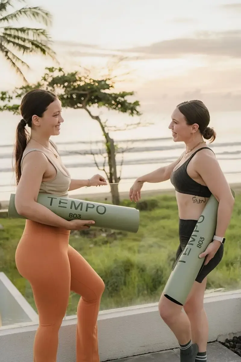 Two women chatting with Tempo 803 mats at sunset on a Bali beach